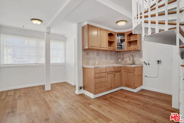 a kitchen with stainless steel appliances granite countertop a sink a stove and a wooden floors