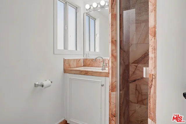 a bathroom with a granite countertop sink and a mirror