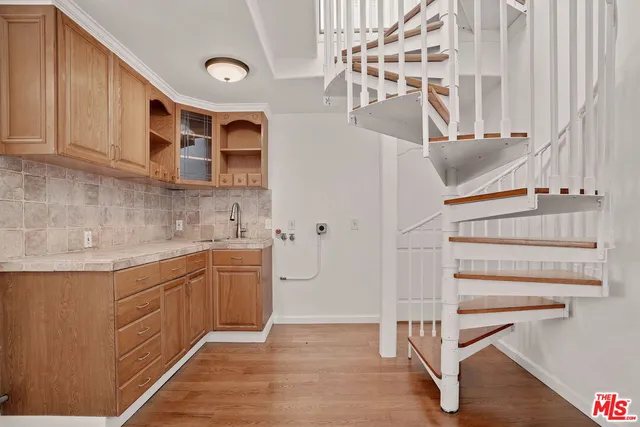 a kitchen with cabinets and wooden floors