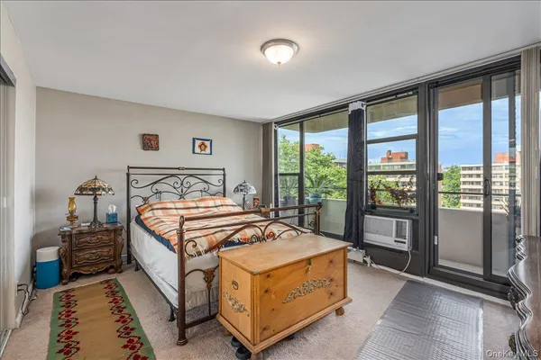 a bedroom with a bed lamp and a large window