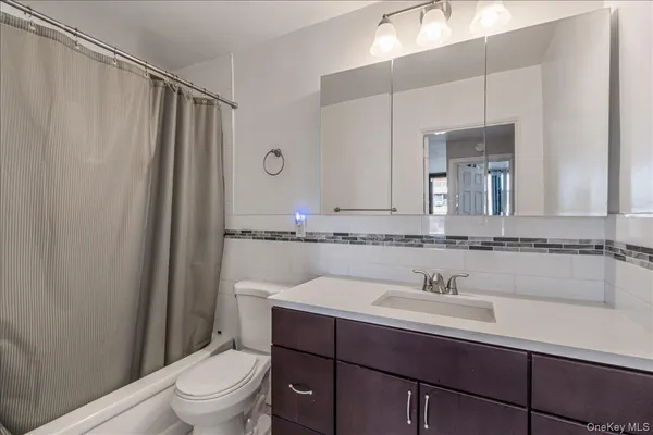 a bathroom with a sink toilet a mirror and shower