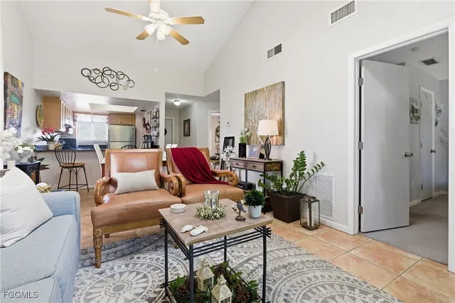 a living room with furniture kitchen view and a chandelier