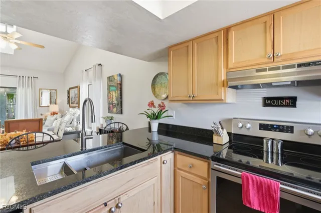 a kitchen with stainless steel appliances granite countertop a stove a sink and a microwave
