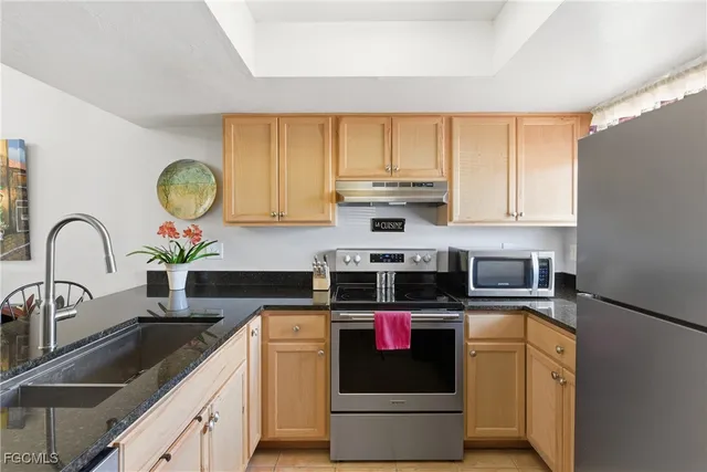 a kitchen with stainless steel appliances granite countertop a refrigerator stove and sink