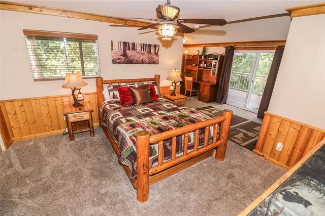 a bedroom with a bed next to a window with a flat screen tv