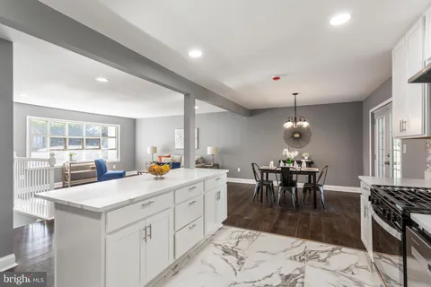 a kitchen with a sink a stove a refrigerator and white cabinets