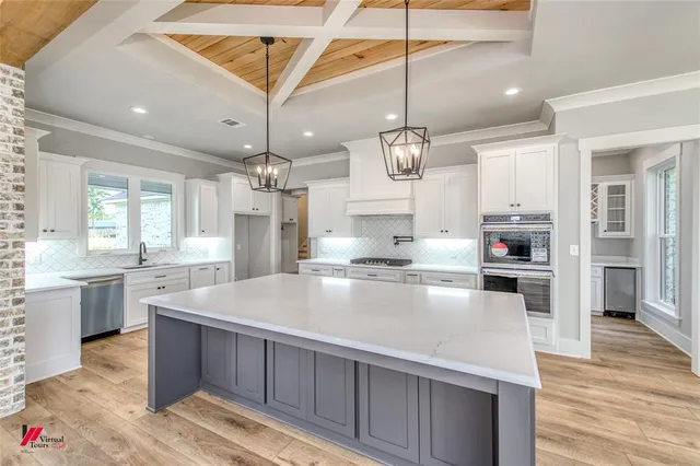 a large kitchen with lots of counter space a sink appliances and cabinets