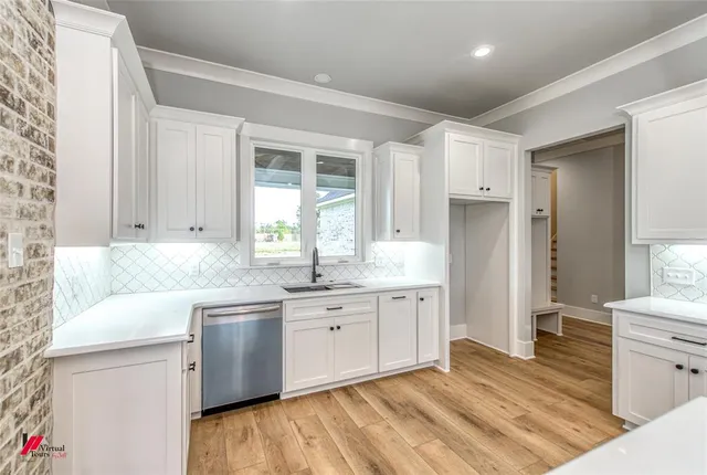 a kitchen with granite countertop a sink stainless steel appliances and cabinets