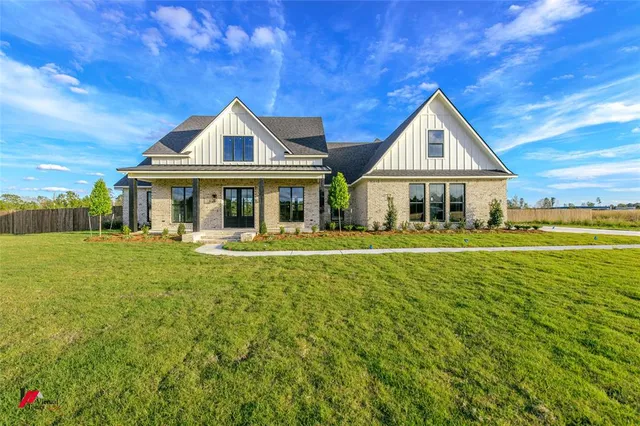a front view of a house with yard and green space
