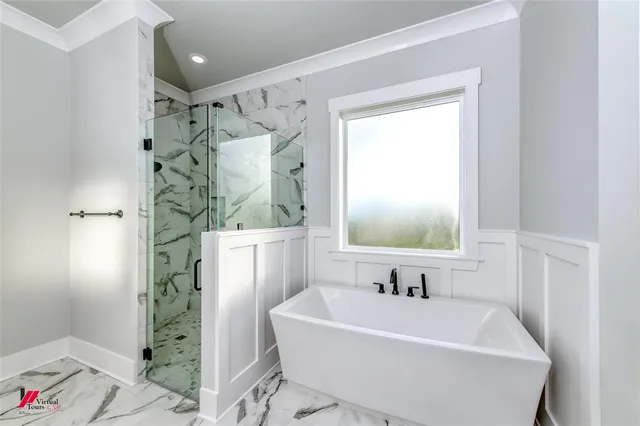a white bath tub sitting next to a white sink and a shower