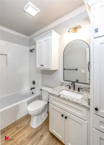 a bathroom with a granite countertop toilet sink and mirror