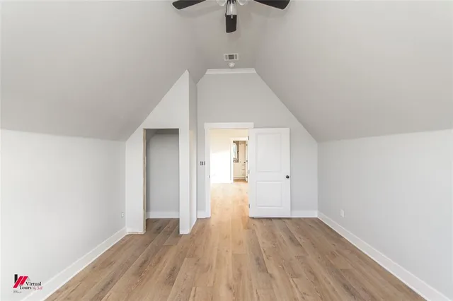 a view of a room with wooden floor ceiling fan and window