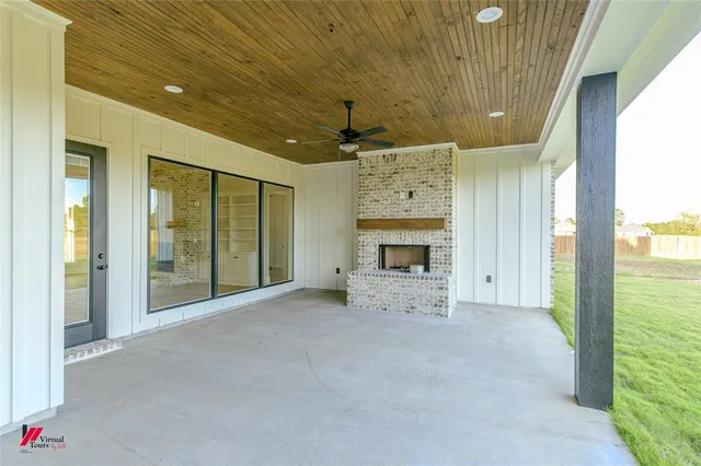 a view of an empty room with a fireplace and a window