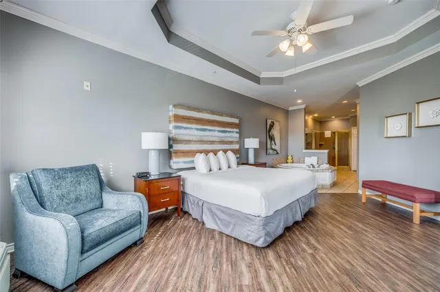 a spacious bedroom with a bed couch chandelier and a window
