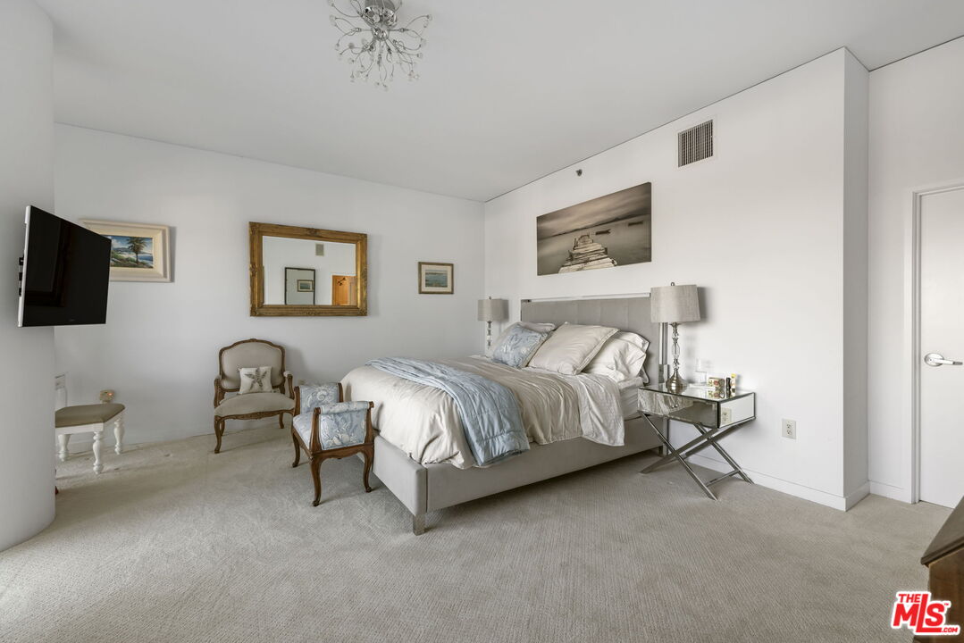 13650 Marina Pointe Drive, Unit 1806 Marina del Rey, CA 90292 - Photo 26 of 65 a bedroom with bed and a chandelier