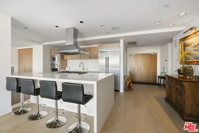 a kitchen with stainless steel appliances kitchen island granite countertop a table and chairs