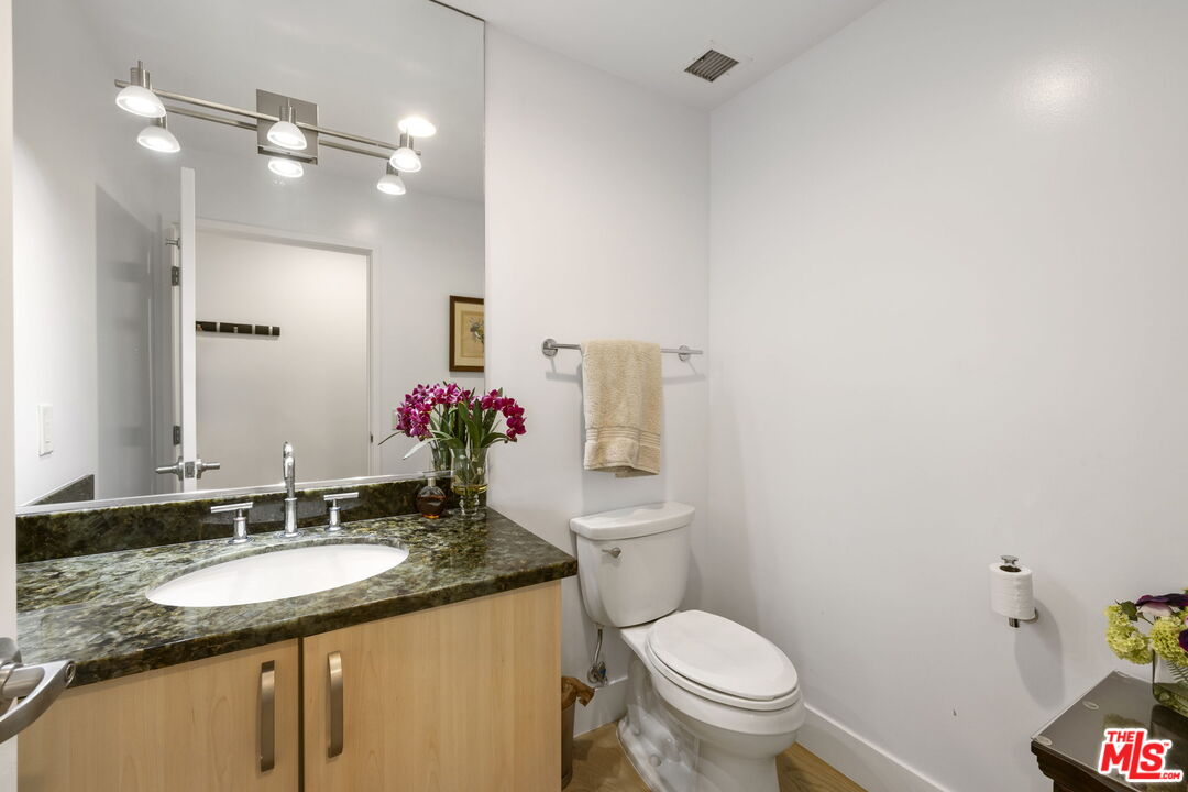 13650 Marina Pointe Drive, Unit 1806 Marina del Rey, CA 90292 - Photo 40 of 65 a bathroom with a granite countertop sink a toilet and a mirror