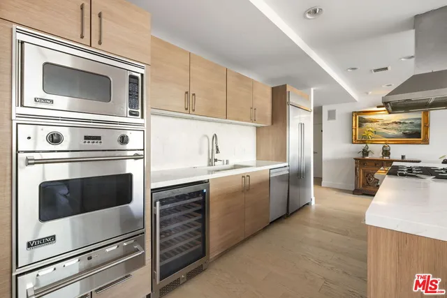 a kitchen with stainless steel appliances white cabinets and a stove top oven