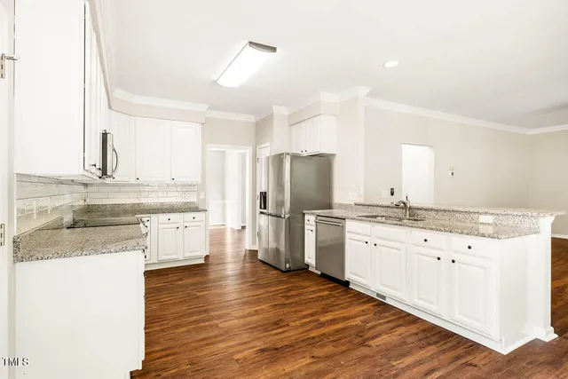 a kitchen with stainless steel appliances granite countertop a sink stove and refrigerator