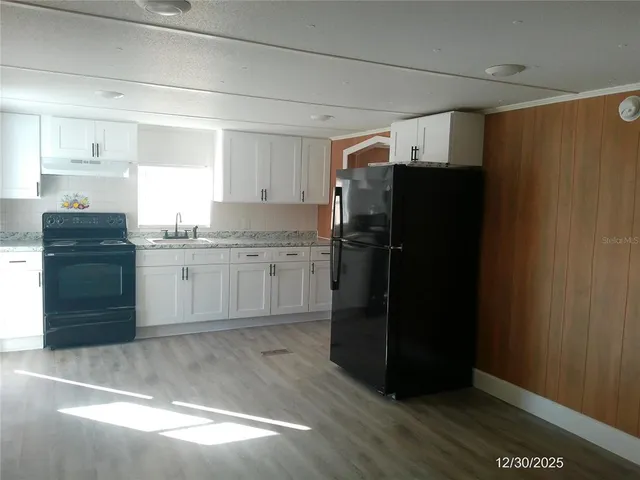 a kitchen with a refrigerator and a sink