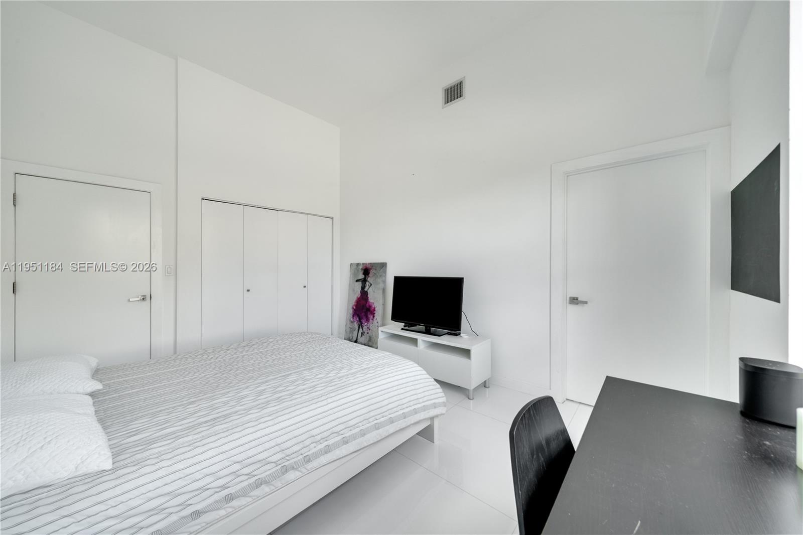 90 Alton Road, Unit TH1 Miami Beach, FL 33139 - Photo 21 of 48 a bedroom with a bed and a flat screen tv