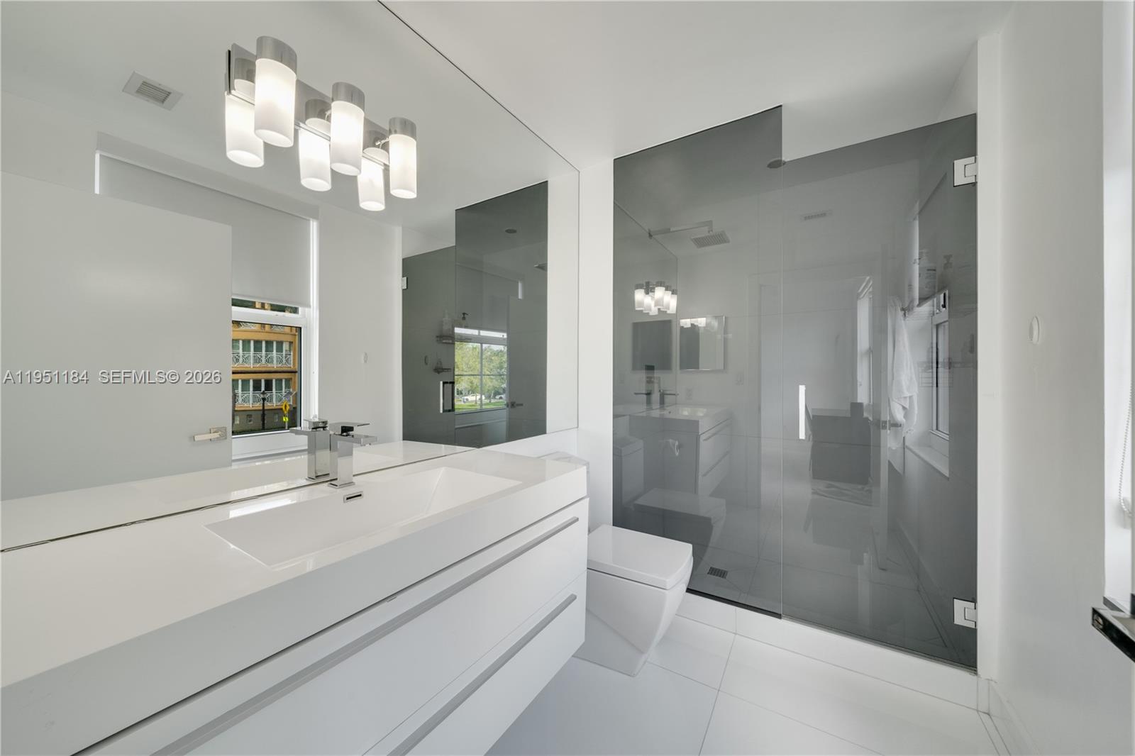 90 Alton Road, Unit TH1 Miami Beach, FL 33139 - Photo 22 of 48 a bathroom with a sink a toilet and shower