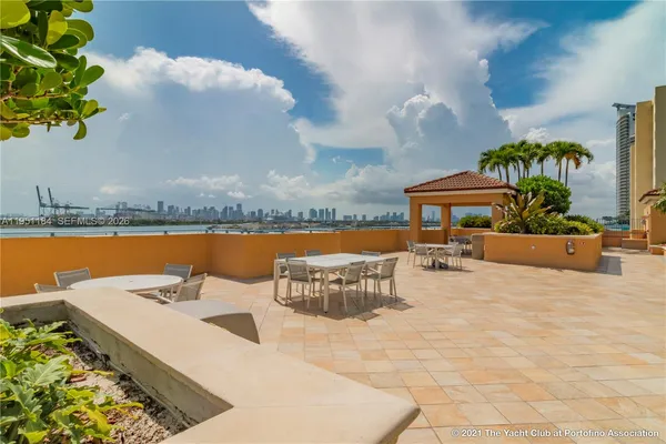 a kitchen with kitchen island stainless steel appliances a sink and a living room view