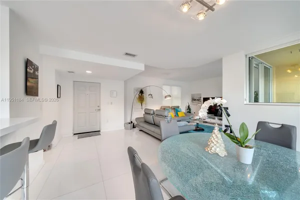 a living room with furniture and a dining table with potted plant