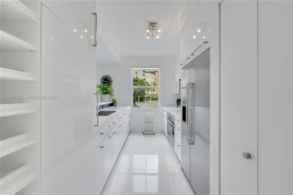 a large white kitchen with cabinets