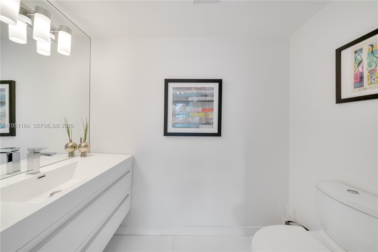 90 Alton Road, Unit TH1 Miami Beach, FL 33139 - Photo 10 of 48 a bathroom with a toilet sink and mirror