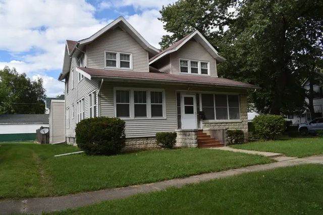 a front view of a house with a yard and outdoor seating