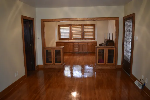 a view of a hallway with wooden floor and a living room