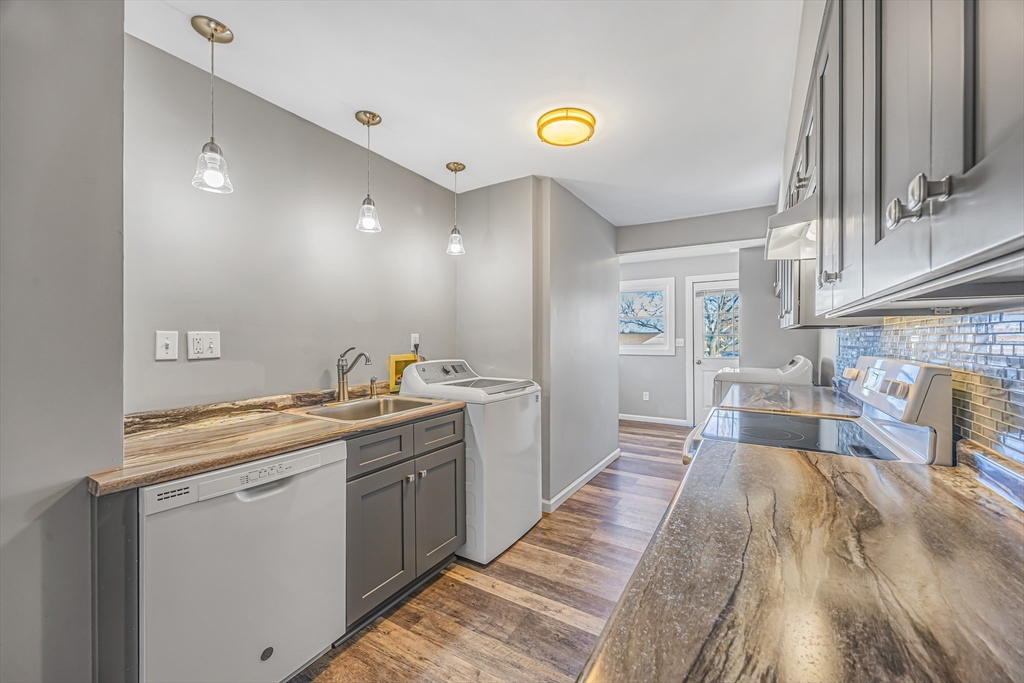 82 Mitchell Drive, Unit 82 Chicopee, MA 01022 - Photo 12 of 31 a view of a kitchen with kitchen island a sink wooden floor and a counter top space
