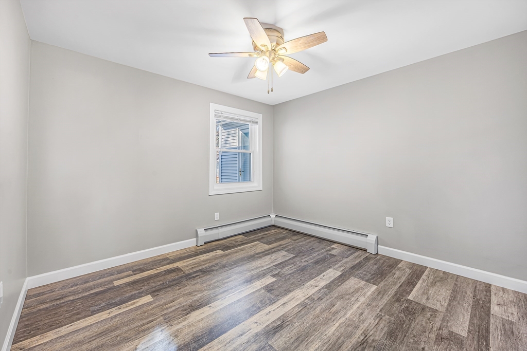 82 Mitchell Drive, Unit 82 Chicopee, MA 01022 - Photo 18 of 31 an empty room with a chandelier fan and windows