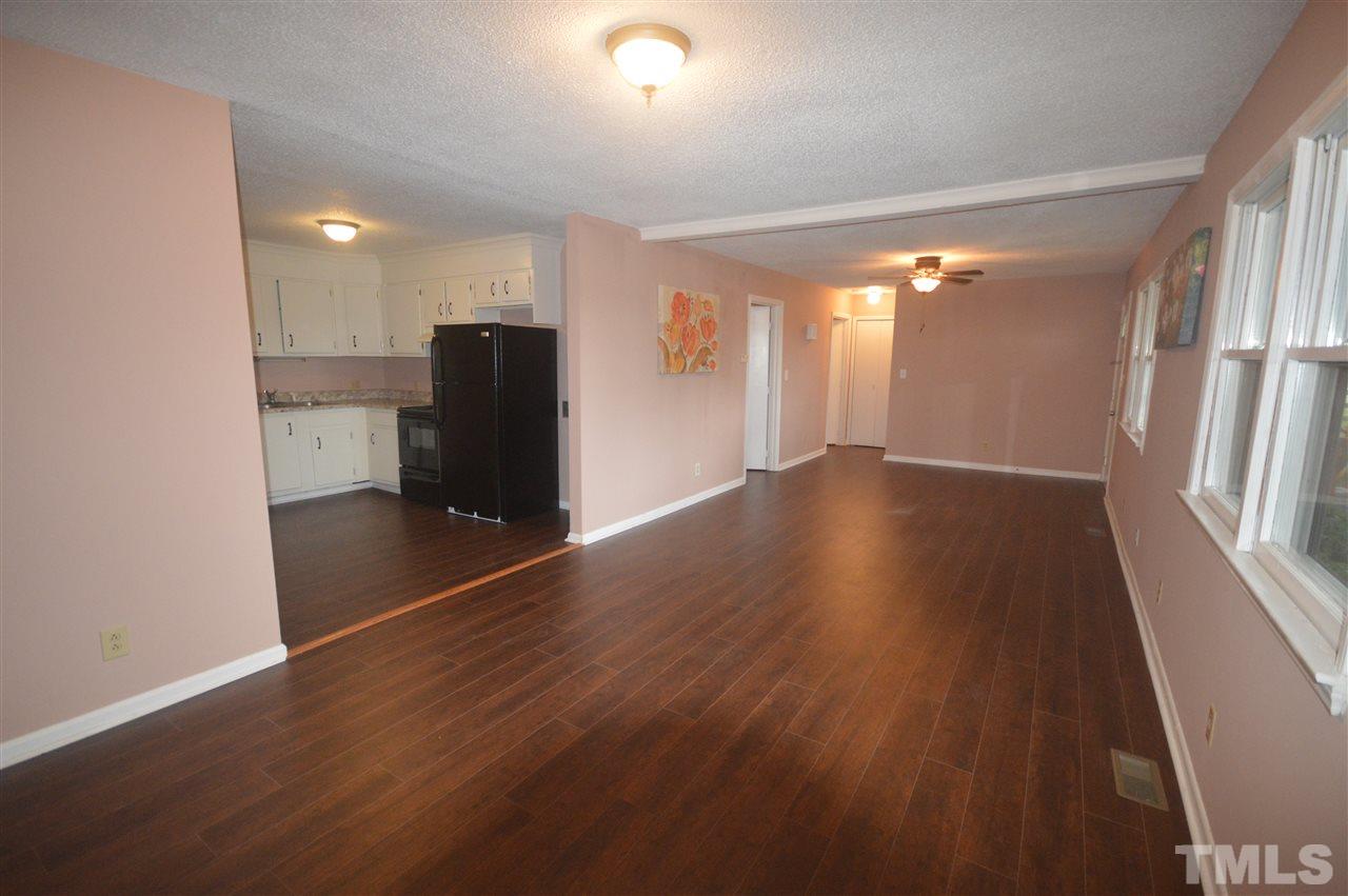 329 Clinton Carlyle Road Zebulon, NC 27597 - Photo 2 of 24 an empty room with wooden floor and windows