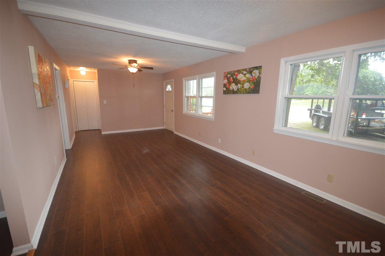 329 Clinton Carlyle Road Zebulon, NC 27597 - Photo 3 of 24 an empty room with wooden floor and windows