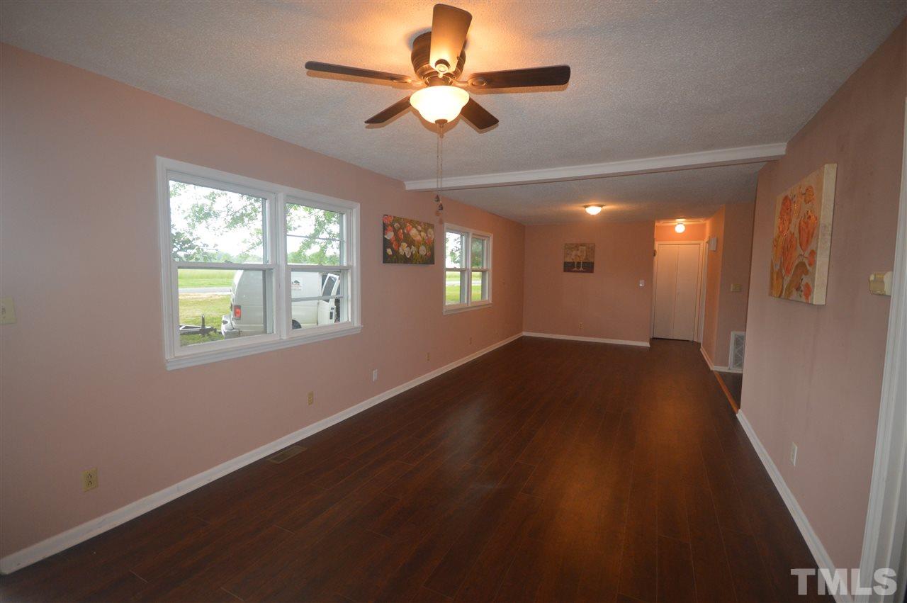329 Clinton Carlyle Road Zebulon, NC 27597 - Photo 5 of 24 a view of an empty room with window and wooden floor
