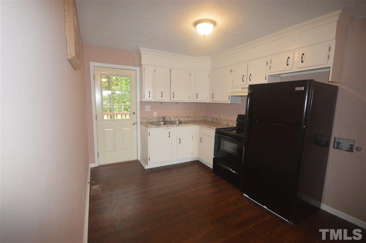 329 Clinton Carlyle Road Zebulon, NC 27597 - Photo 7 of 24 a kitchen with a refrigerator a stove a microwave and cabinets