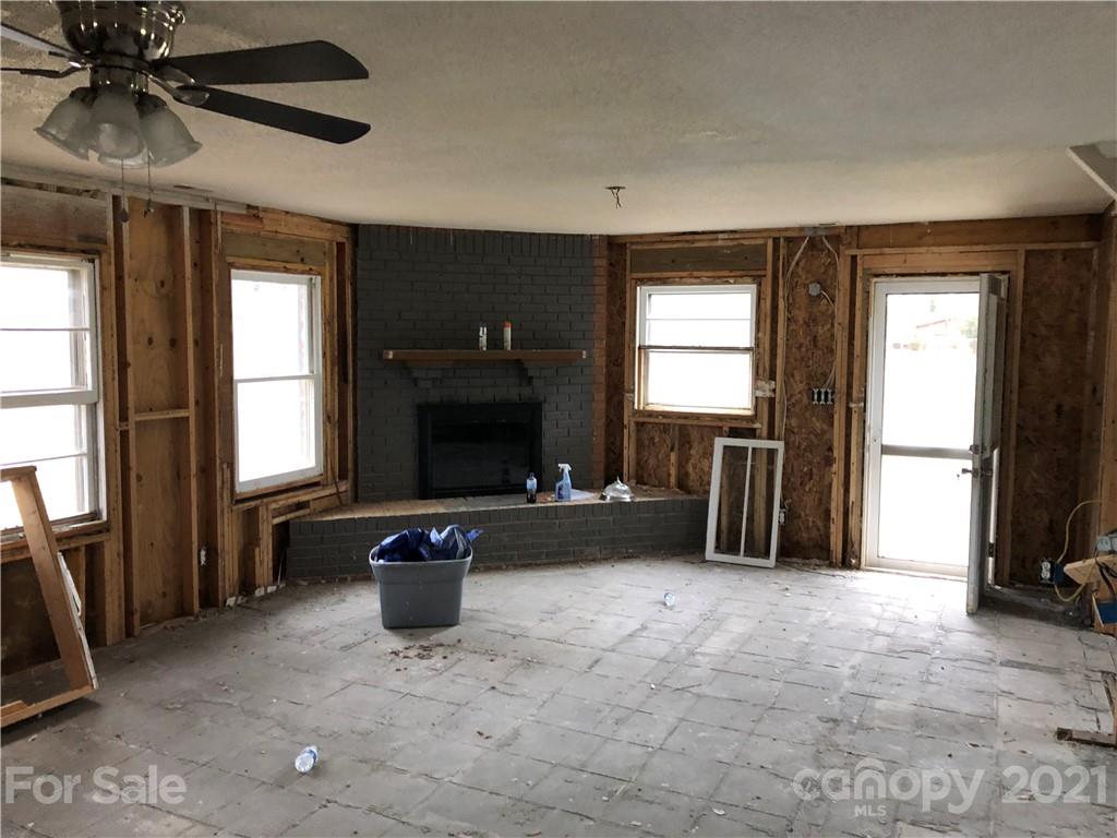 1420 Riverside Drive Charlotte, NC 28214 - Photo 10 of 13 a living room with furniture a flat screen tv and a fireplace