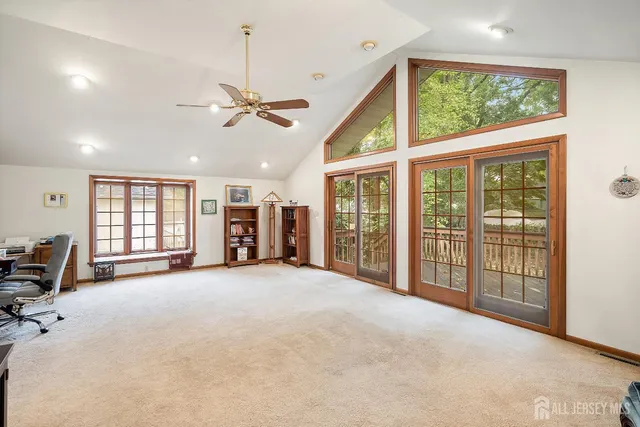 a view of a livingroom with furniture chandelier and windows
