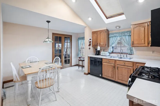 a kitchen with stainless steel appliances granite countertop a sink a stove a dining table and chairs