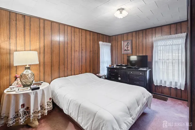 a bedroom with a bed and dresser with mirror