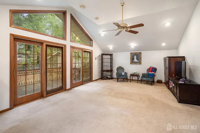 a view of a livingroom with furniture entryway wooden floor and fan