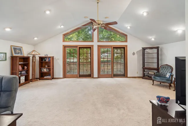 a view of an empty room with furniture and a large window