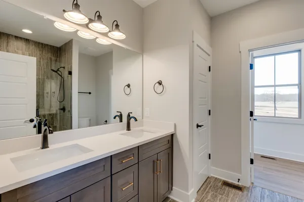 a bathroom with a sink a large mirror and shower