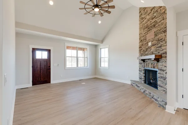 an empty room with windows and fireplace