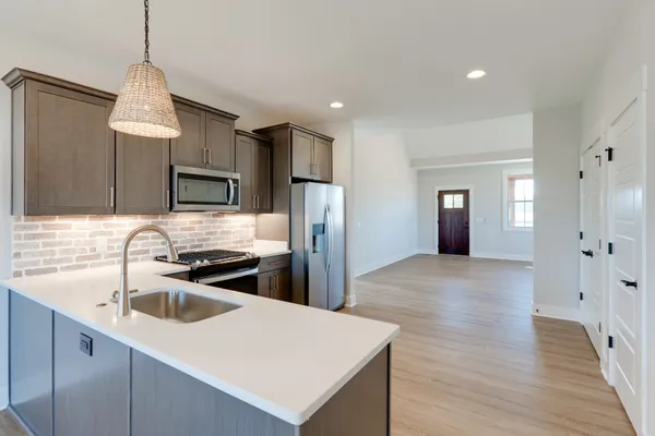 a kitchen that has a sink cabinets counter space and appliances