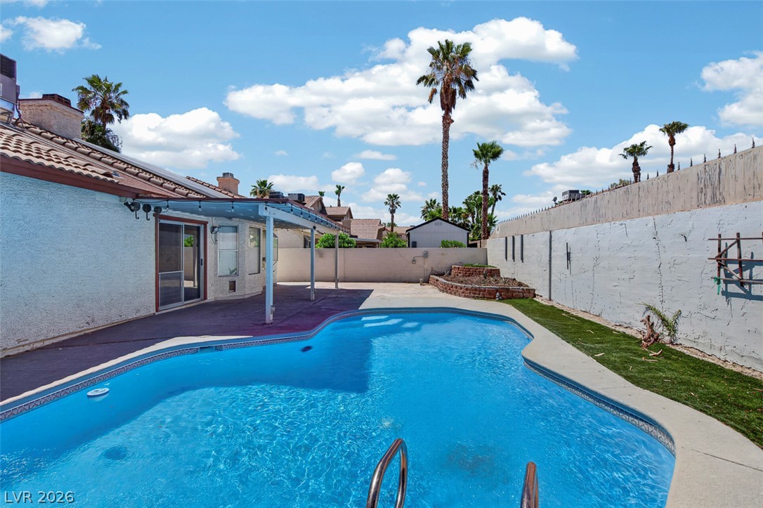 2609 Shakespeare Road Las Vegas, NV 89108 - Photo 34 of 41 A private backyard oasis features a free-form swimming pool with a covered patio.