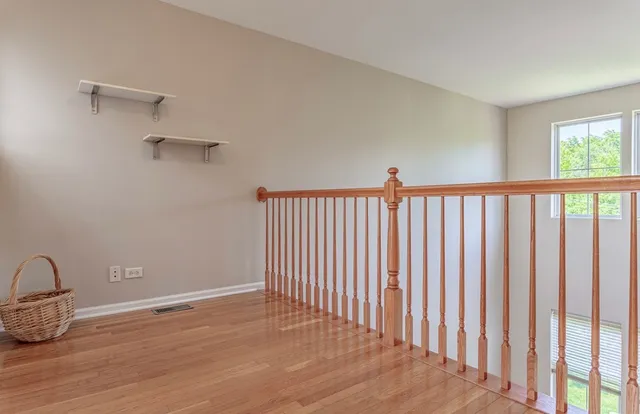 a view of a room with wooden floor and fan