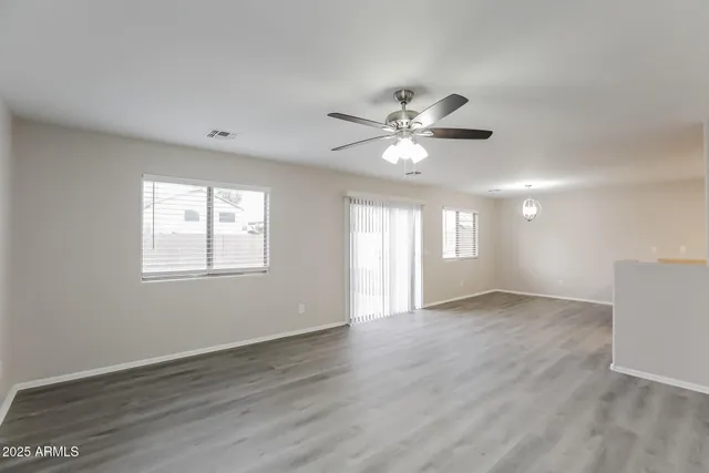 an empty room with wooden floor and window